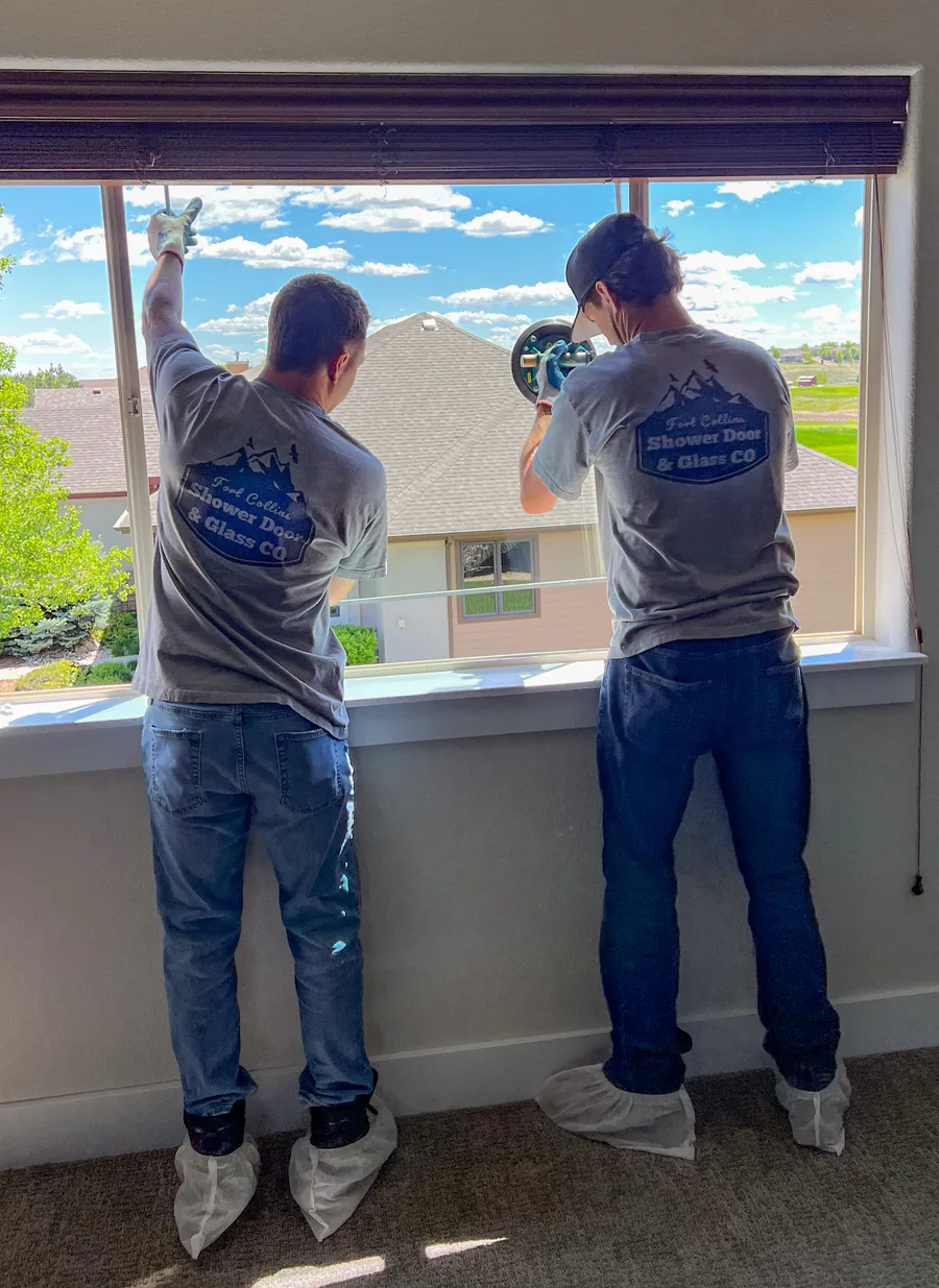 Two Fort Collins Shower Door and Glass installers replacing a large window