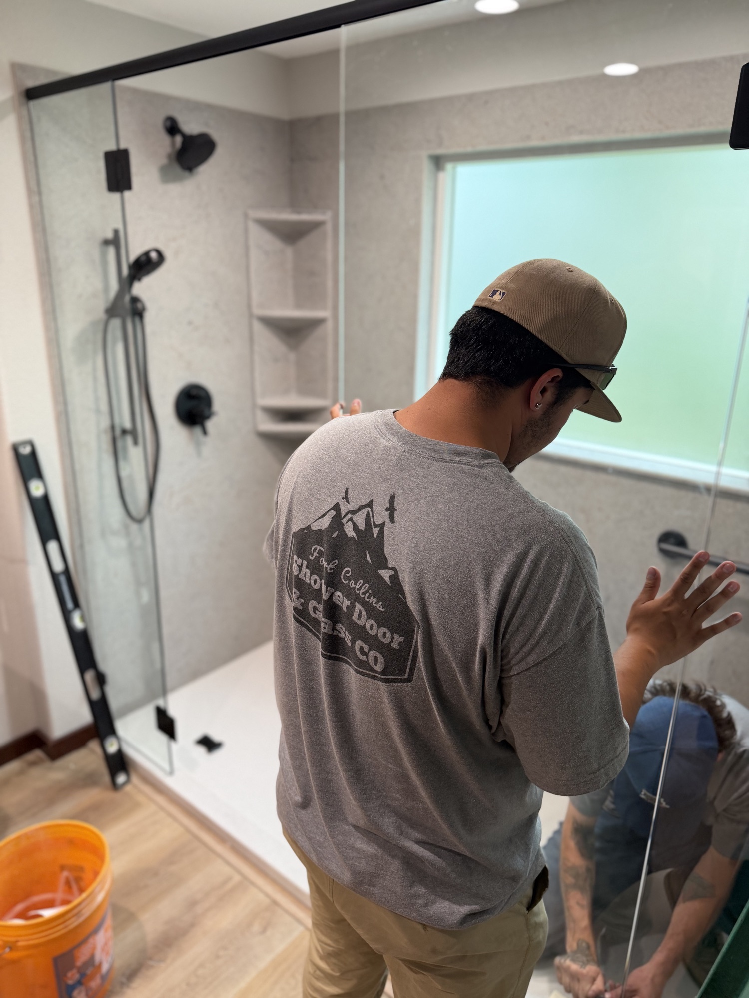 Fort Collins Shower Door and Glass installer completing a custom glass shower enclosure