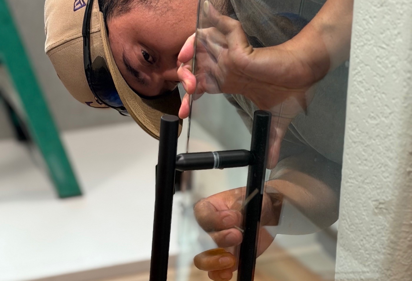 Fort Collins Shower Door and Glass installer aligning the hardware on a custom glass shower enclosure